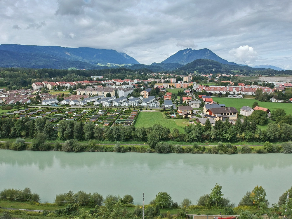 Drohnenfoto – Weitwinkelansicht von Villach und der Drau im Sommer.